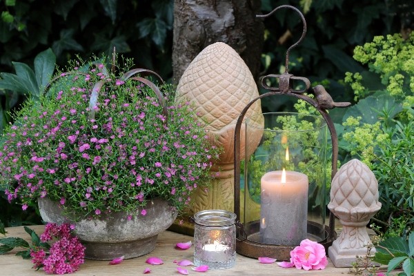 Gartendekoration mit Kerzen und Sommerblumen