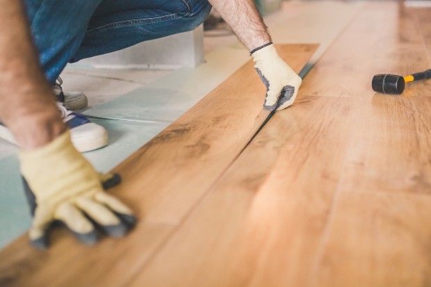 Mann verlegt Laminatboden in Holzoptik - dies ist kein Echtholz