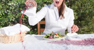 Frau verschüttet Rotwein am Tisch - Rotweinflecken vom Holztisch entfernen