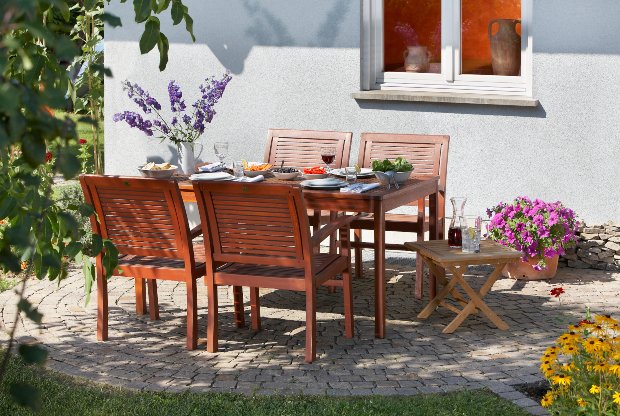 Auf der Terrasse steht ein mit Blumen dekorierter und gedeckter Tisch