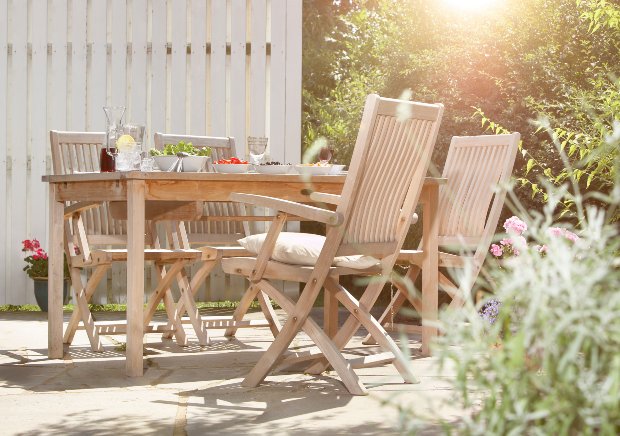 Ein gedeckter Tisch und mehrere Stühle auf einer schönen Terrasse laden dazu ein, Platz zu nehmen