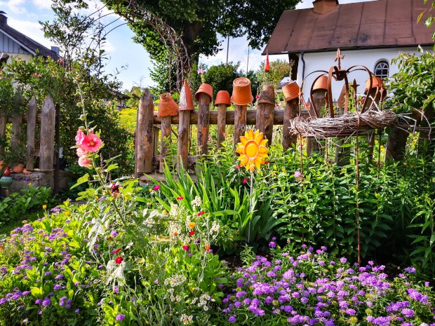 Bauerngarten mit bunten Blumen an einem Haus