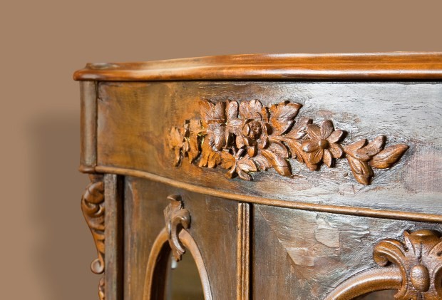 Zu sehen sind die opulenten Schnitzereien eines antiken Holzmöbelstücks Britischer Wohnstil