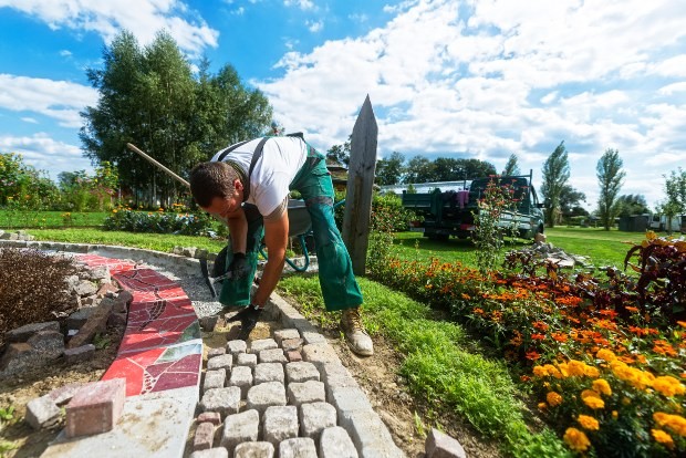 Mann legt Steinweg im Garten an - Englischer Garten - Englischen Garten anlegen