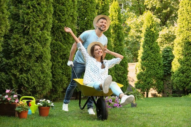 Paar im Garten - Mann schiebt Frau in Schubkarre - Englischer Garten - Englischen Garten anlegen