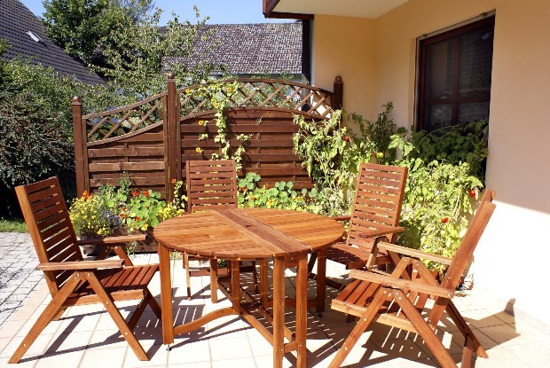 Gartenterrasse mit Holzmöbeln und Grünpflanzen - Terrassen-Gestaltungsmöglichkeiten im Landhausstil