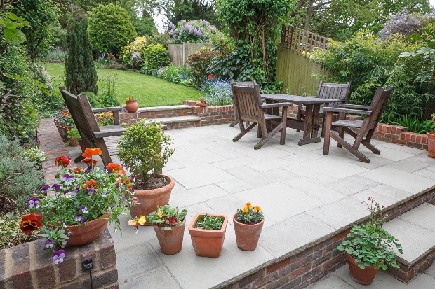 Gartenterrasse mit Teakmöbeln und Pflanzenkübeln