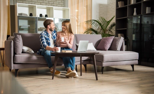 Junges Paar sitzt auf Couch im Wohnzimmer