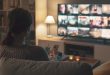Junge-Frau-schaut-fern - TV-Wand - Ideen für den Fernseher