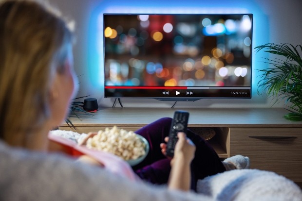 Junge-Frau-schaut-fern-Ambilight-TV - TV-Wand - Ideen für den Fernseher