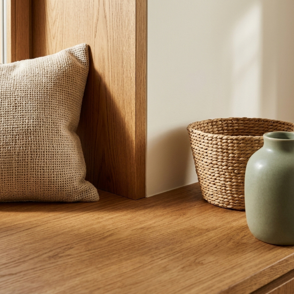 Naturmaterialien im modernen Landhausstil Detailaufnahme von Massivholz, Leinenkissen, Korb und Keramik als Naturmaterialien im modernen Landhaus-Wohnzimmer